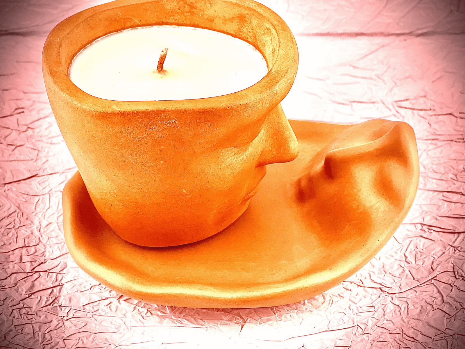 Side view of Lucentius Twin Flame candle with man face relief on female tray, showing concrete texture and sculptural detail, unlit